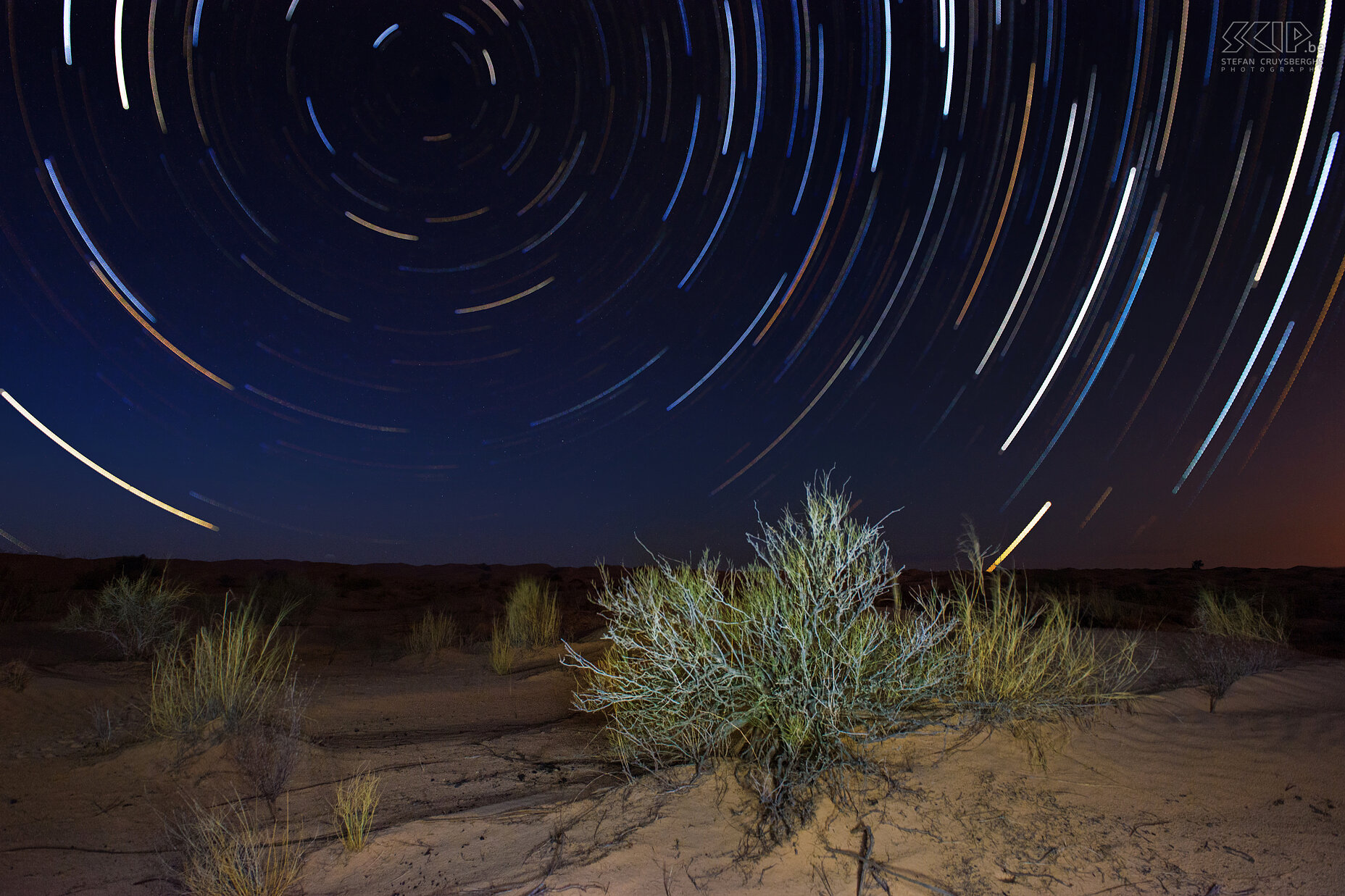 Star trails This is my first star trails photo. I first used my flash light to lighten the foreground in combination with the ambient light during twilight. Then I started to make 30 second exposures for 1,5 hour between dusk and moon rise by using the interval feature in my new Nikon D600. I finally combined these photos and the result is this photo which shows very colourful star trails. Stefan Cruysberghs